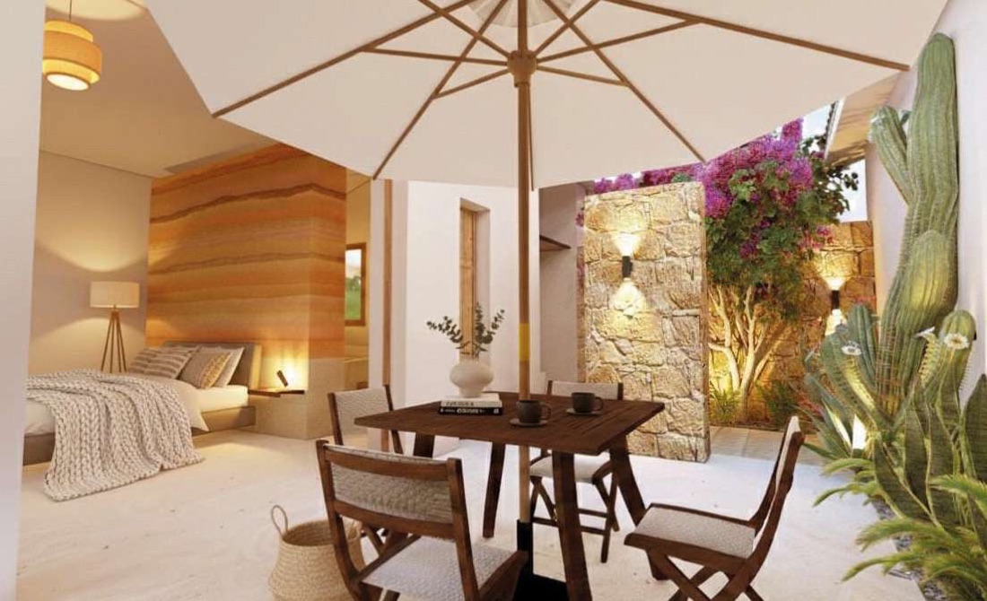 Interior de la suite con muro cabecero de tapia de colores y terraza con comedor